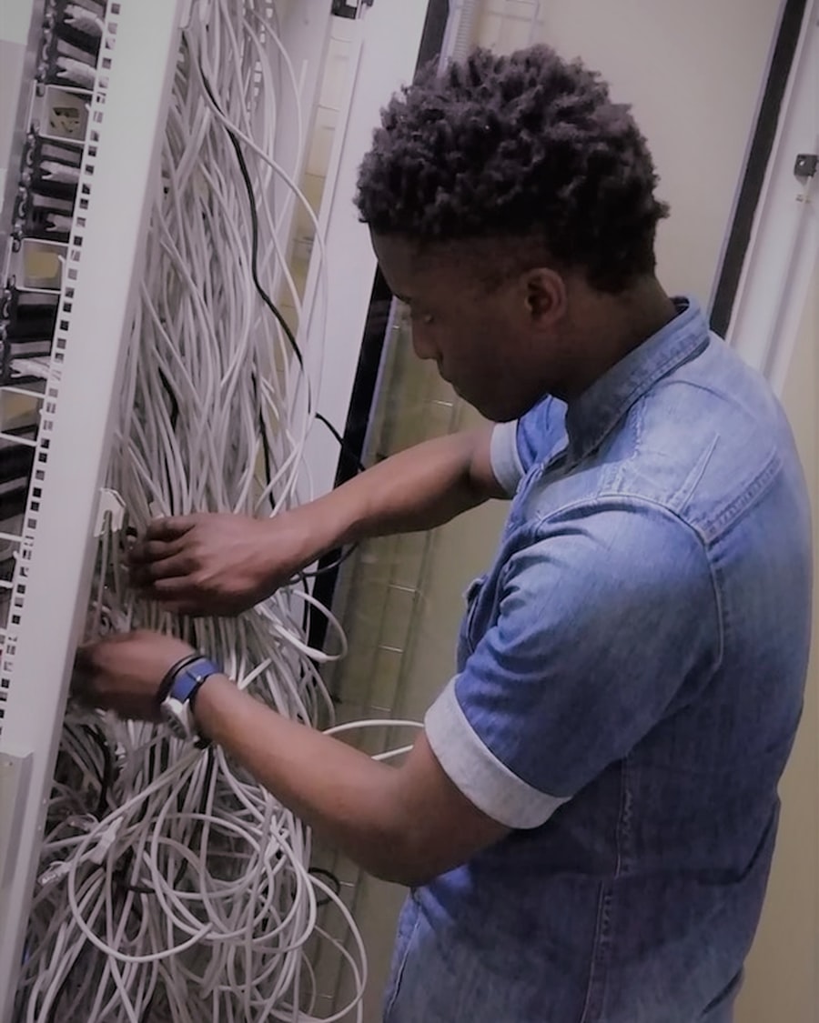 An engineer terminating and dressing network cabling in a rack